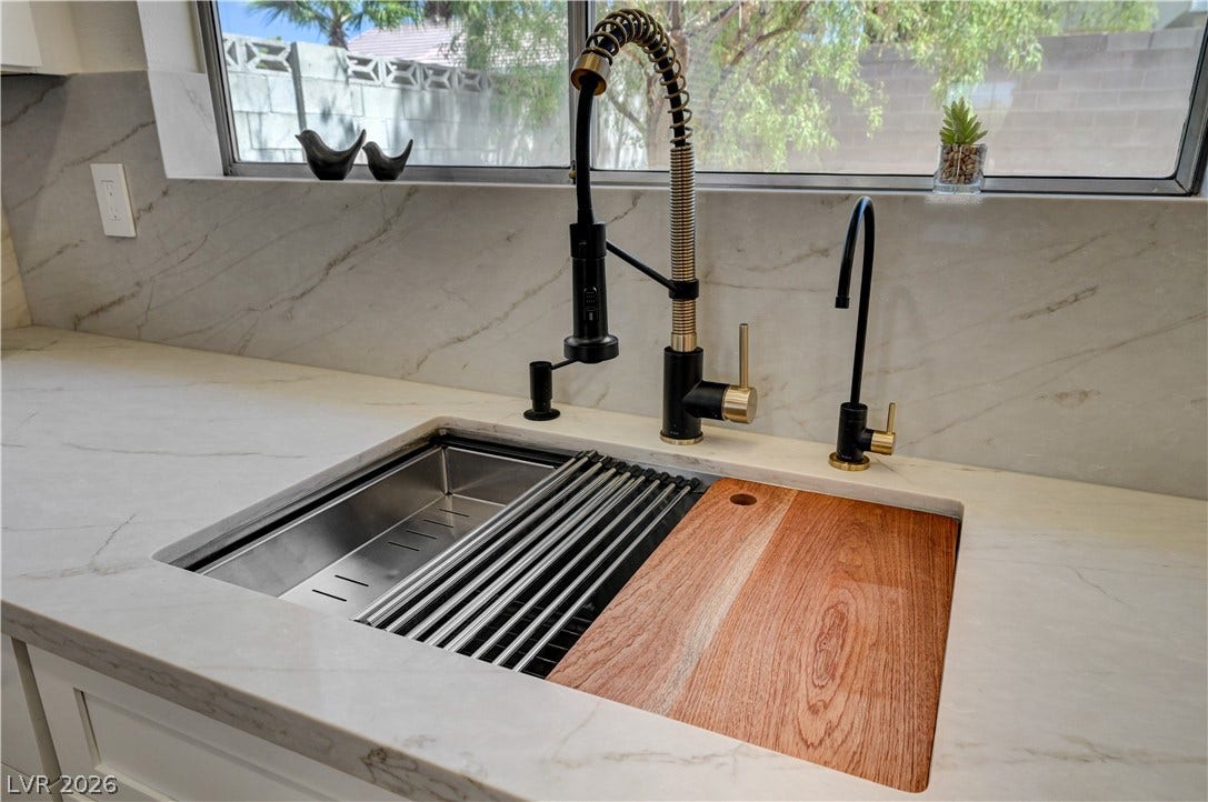 3131 White Rose Way, Henderson, NV 89014 Premium kitchen sink featuring a cutting board and drain rack insert for versatile food preparation.