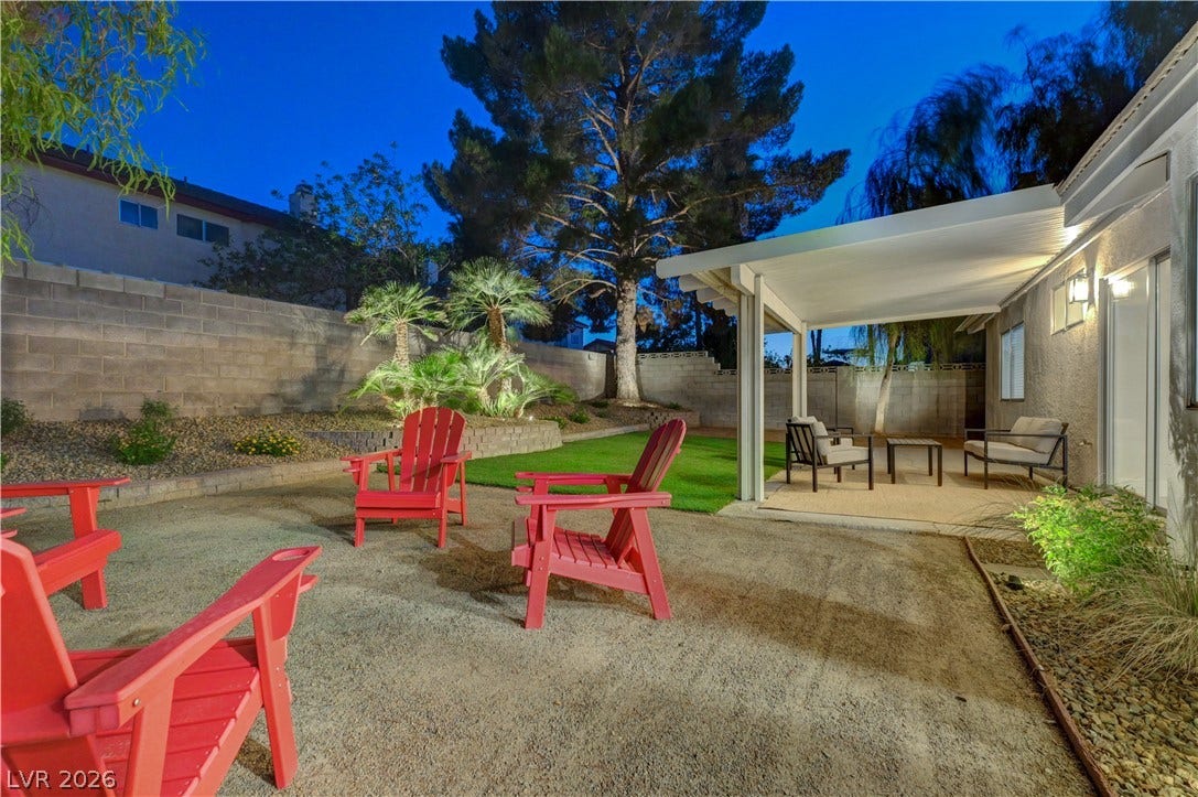 3131 White Rose Way, Henderson, NV 89014 Illuminated landscaping enhances this spacious backyard, featuring a covered patio and a charming fire pit area.