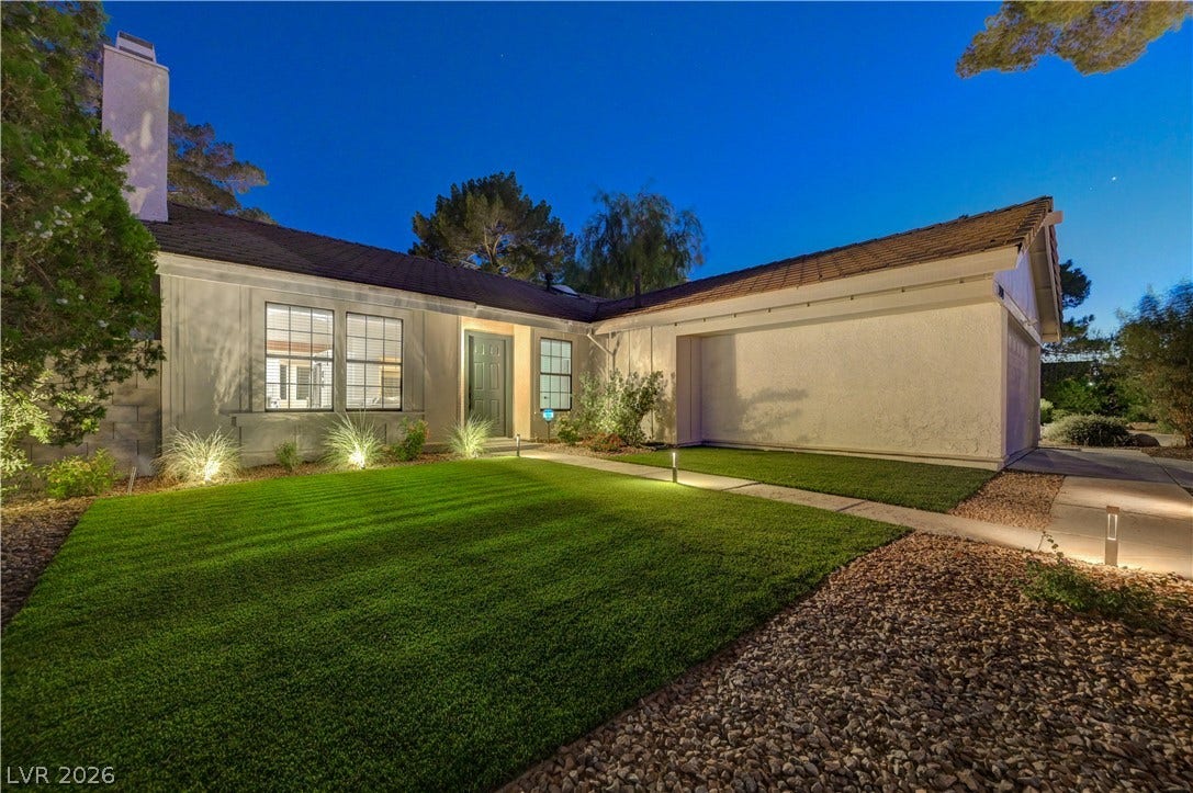 3131 White Rose Way, Henderson, NV 89014 Illuminated by night, this charming residence features manicured lawns and subtle landscape lighting.