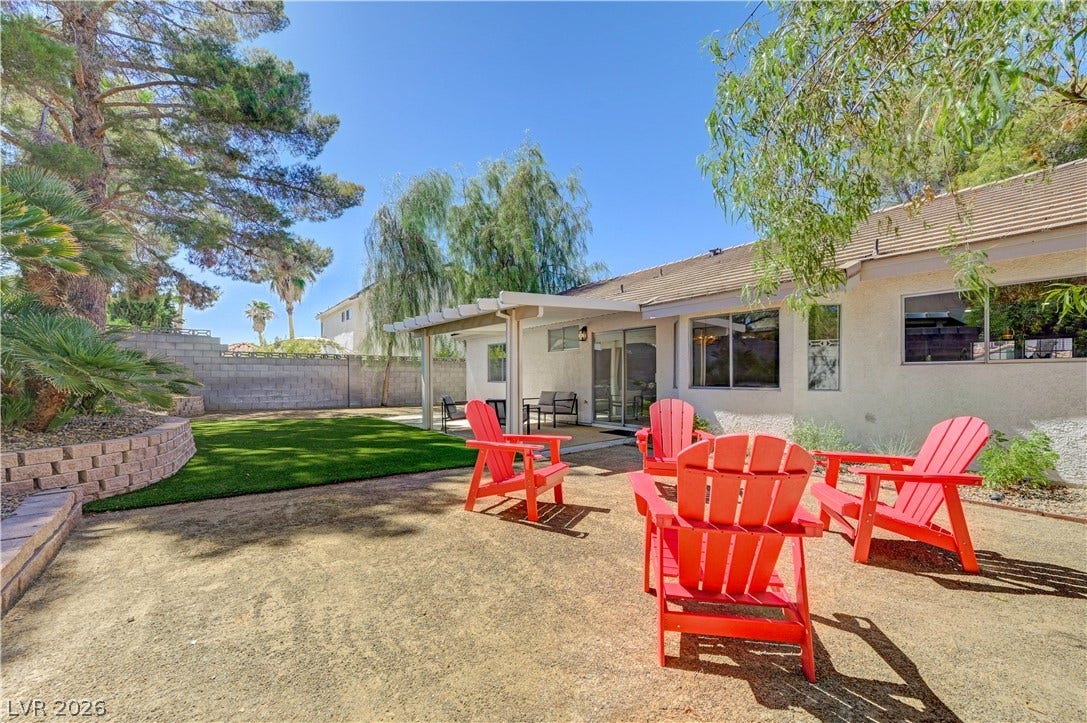 3131 White Rose Way, Henderson, NV 89014 A spacious yard boasts a covered patio, ideal for outdoor relaxation and entertaining.