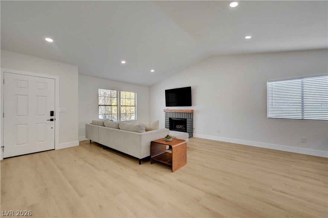3131 White Rose Way, Henderson, NV 89014 A generous living area presents a fireplace, high ceilings, and ample flooring.