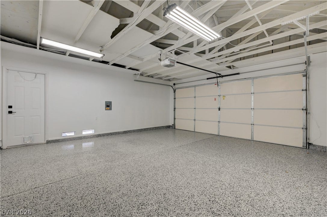 3131 White Rose Way, Henderson, NV 89014 A well-maintained garage with durable speckled flooring and overhead lighting awaits your vehicles.