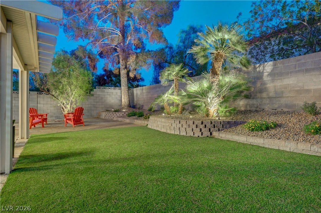 3131 White Rose Way, Henderson, NV 89014 A vibrant lawn meets structured landscaping, offering a tranquil outdoor retreat.