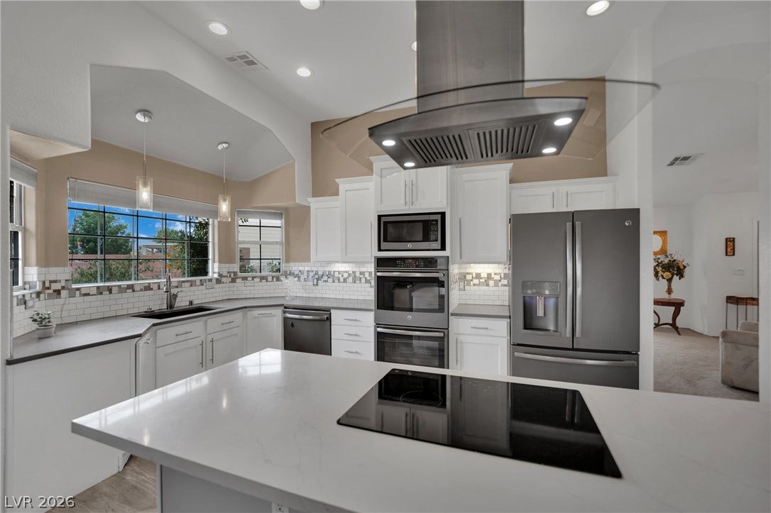 9180 Mohawk Street, Las Vegas, NV 89139 Kitchen with stainless steel appliances, white cabinetry, hanging light fixtures, island range hood, and decorative backsplash