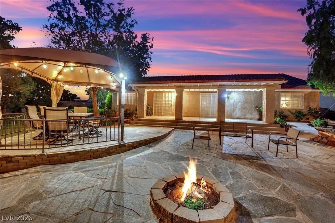 9180 Mohawk Street, Las Vegas, NV 89139 Patio terrace at dusk with outdoor dining area, a patio area, a fire pit, and a gazebo