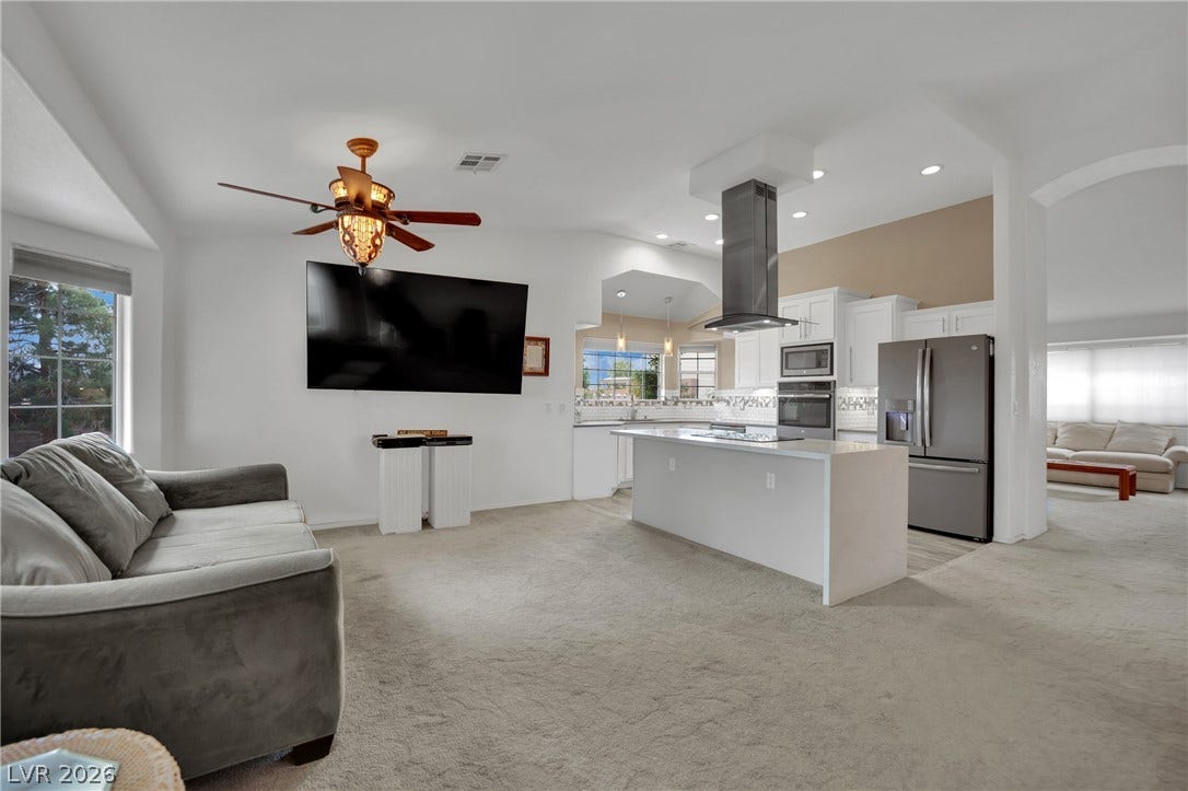 9180 Mohawk Street, Las Vegas, NV 89139 Living area with light colored carpet, ceiling fan, recessed lighting, vaulted ceiling, and arched walkways
