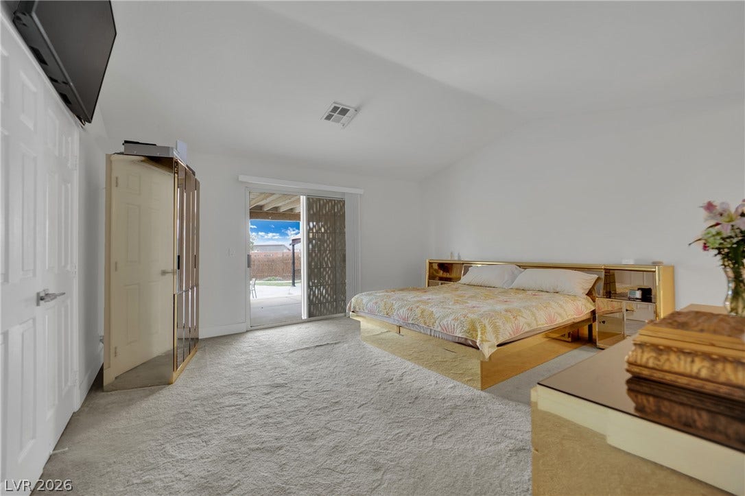 9180 Mohawk Street, Las Vegas, NV 89139 Bedroom featuring light carpet, access to exterior, and vaulted ceiling