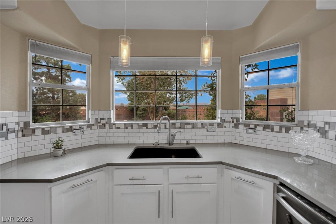 9180 Mohawk Street, Las Vegas, NV 89139 Kitchen with white cabinetry, pendant lighting, dishwasher, and light stone countertops