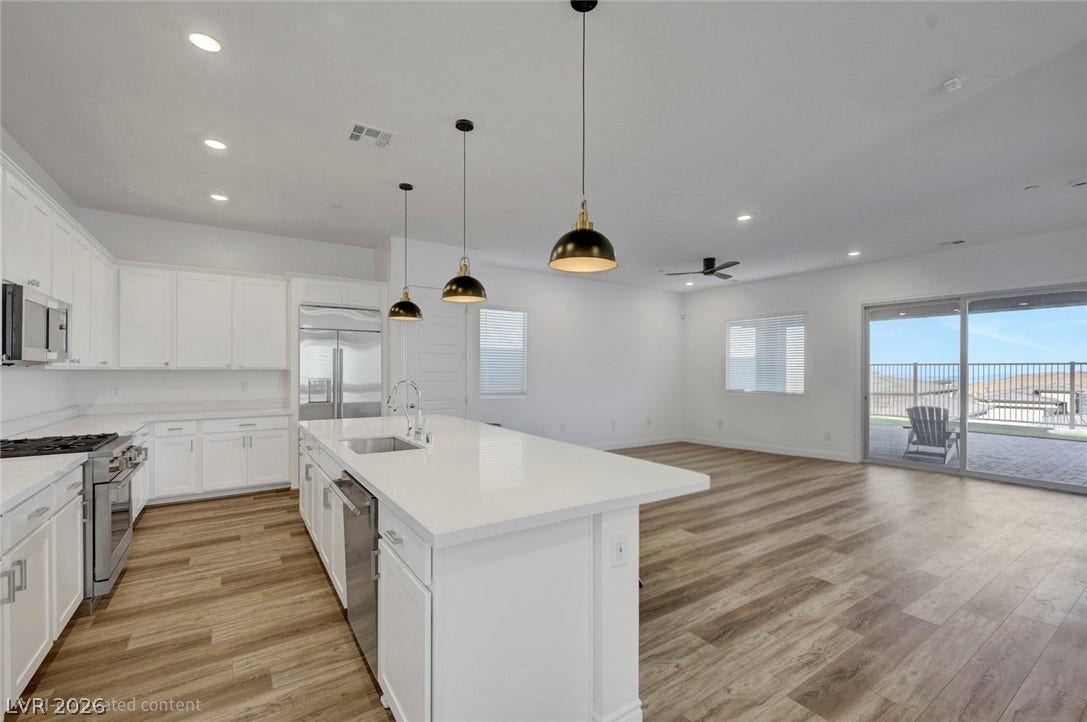 Gleaming wood-look flooring extends through an open-concept living area and a sleek, well-equipped kitchen.