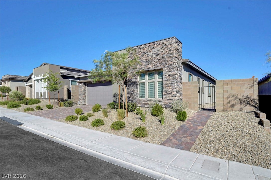 A modern facade with striking stone accents and thoughtful desert-friendly landscaping invites residents home.