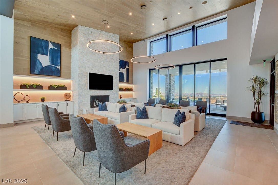 Vast windows capture commanding views in this elegant living area with a contemporary fireplace and soaring ceilings.
