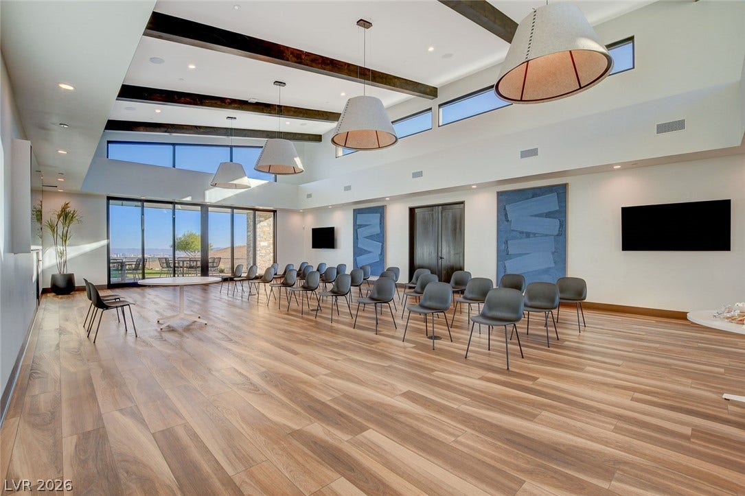 A spacious common area with elevated ceilings and floor-to-ceiling glass doors offers an ideal setting for gatherings.