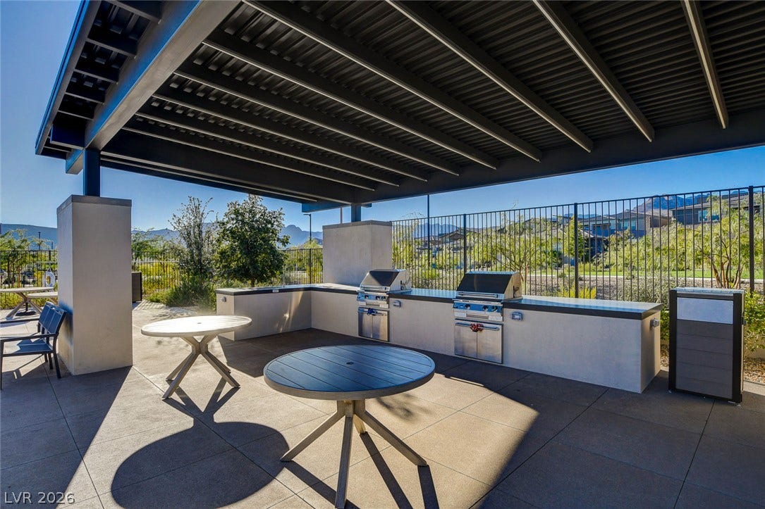A well-appointed outdoor kitchen and shaded patio area await al fresco dining.