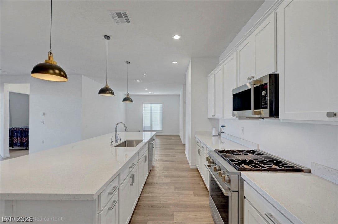 Modern kitchen with sleek white cabinetry and an inviting island for culinary creations.