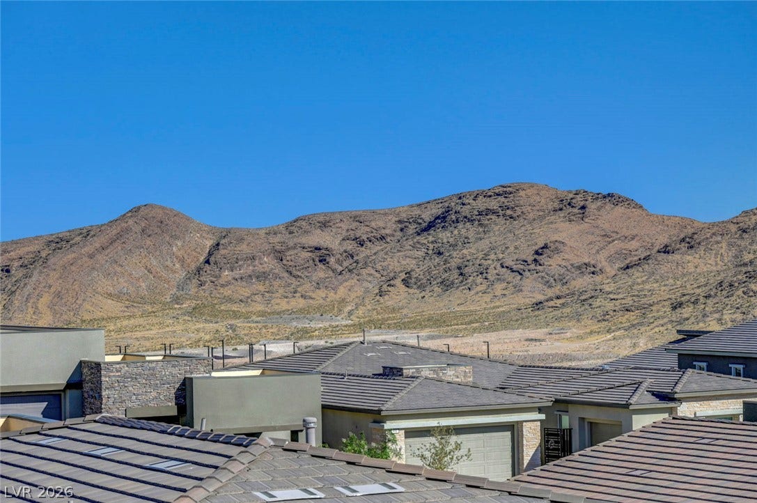 Dramatic mountain backdrops create an impressive natural vista over these modern residential roofs.