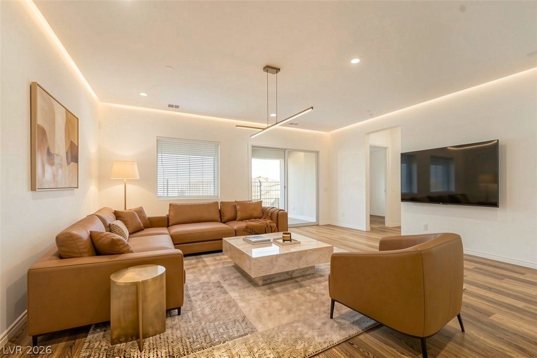 Recessed lighting illuminates this inviting living space, showcasing rich hardwood flooring and convenient sliding doors to a private balcony.