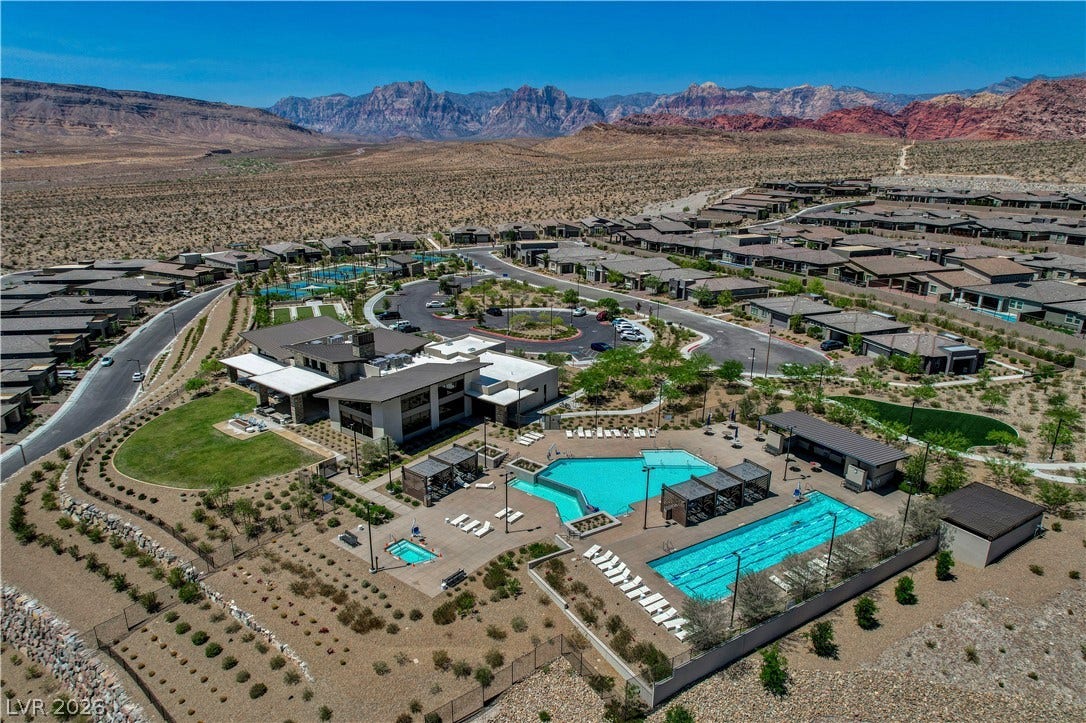 An aerial panorama reveals a desert community with recreational amenities nestled against mountain vistas.