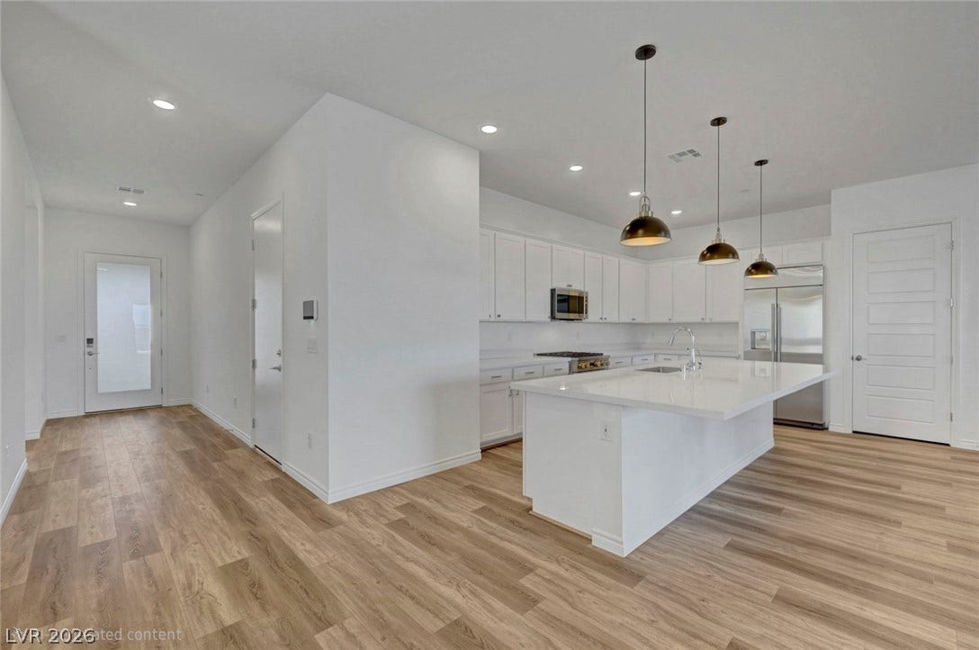 Bright, open-concept kitchen boasts a generous island and modern pendant lighting.