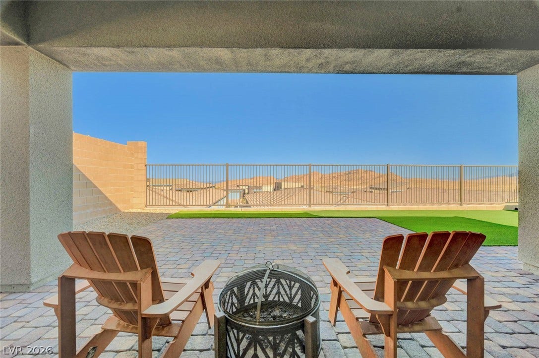 Enjoy the sweeping desert vistas from a paved patio featuring artificial turf and a cozy fire pit.