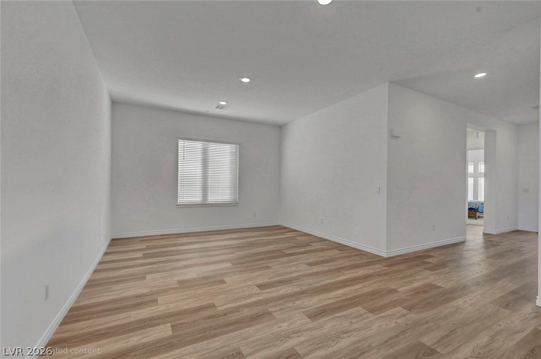 A well-lit, versatile room with elegant wood flooring, ready for personalization.