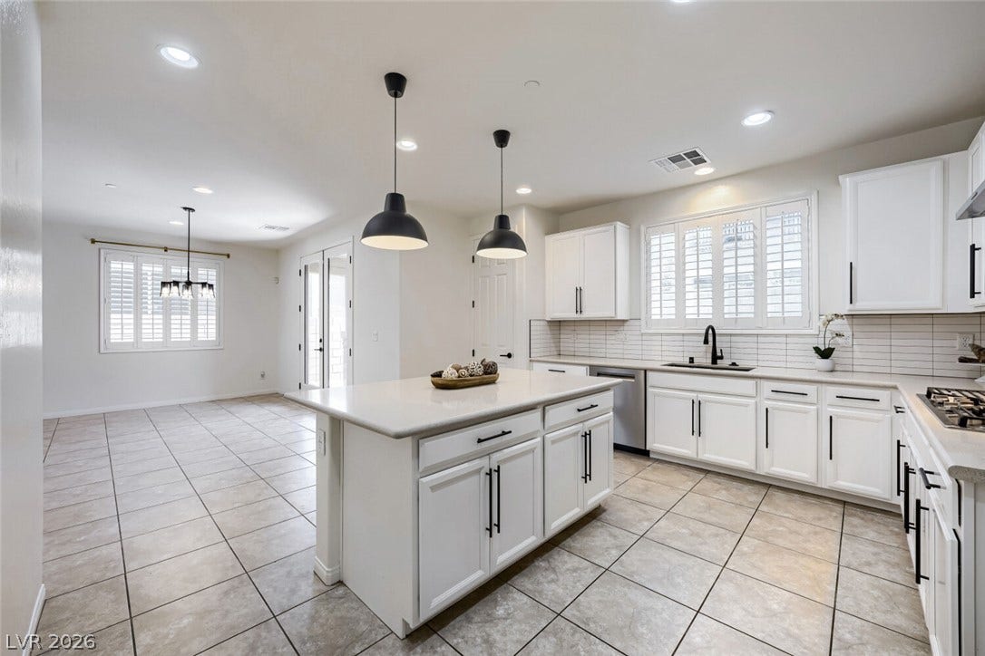 189 Lilt Avenue, Henderson, NV 89011 Culinary excellence awaits with an expansive kitchen island and contemporary white cabinetry.