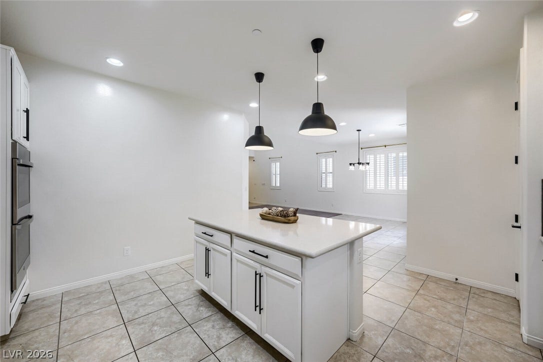 189 Lilt Avenue, Henderson, NV 89011 A streamlined kitchen island anchors this inviting space, leading into a light-filled living area.