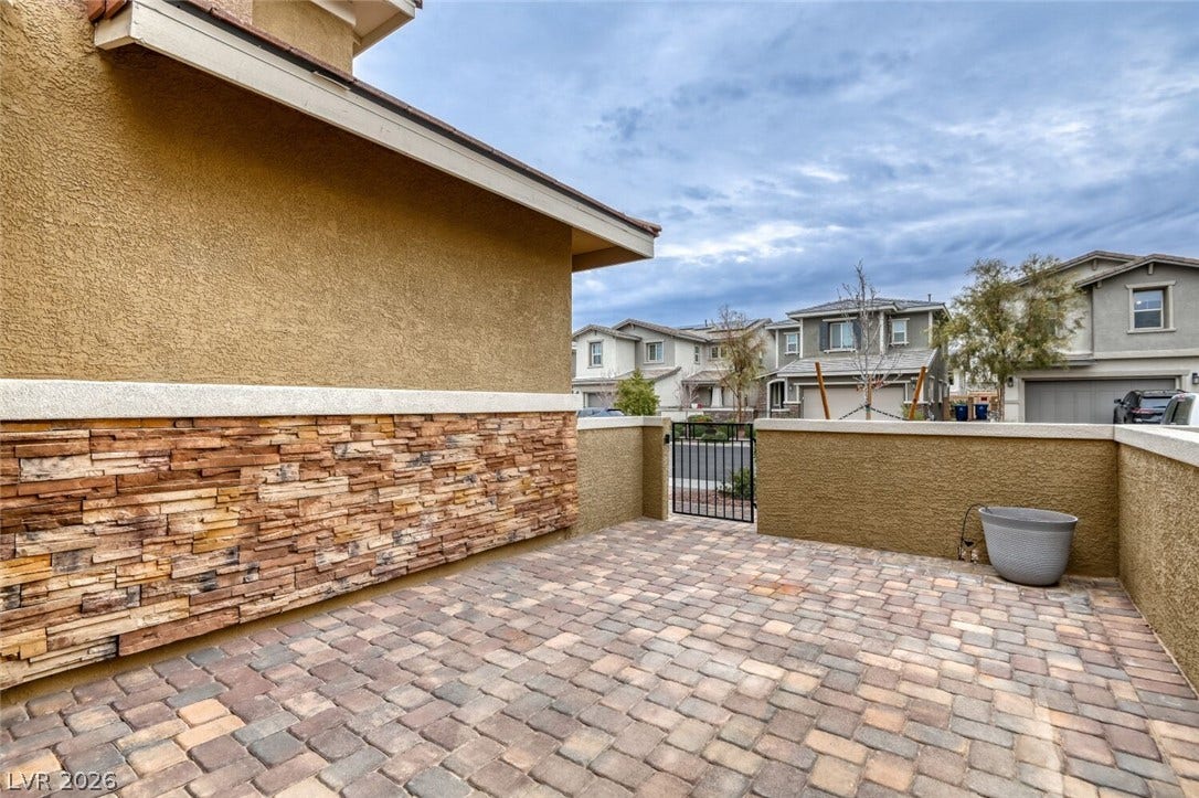189 Lilt Avenue, Henderson, NV 89011 A private outdoor space features a decorative paver patio and a charming stone veneer wall.
