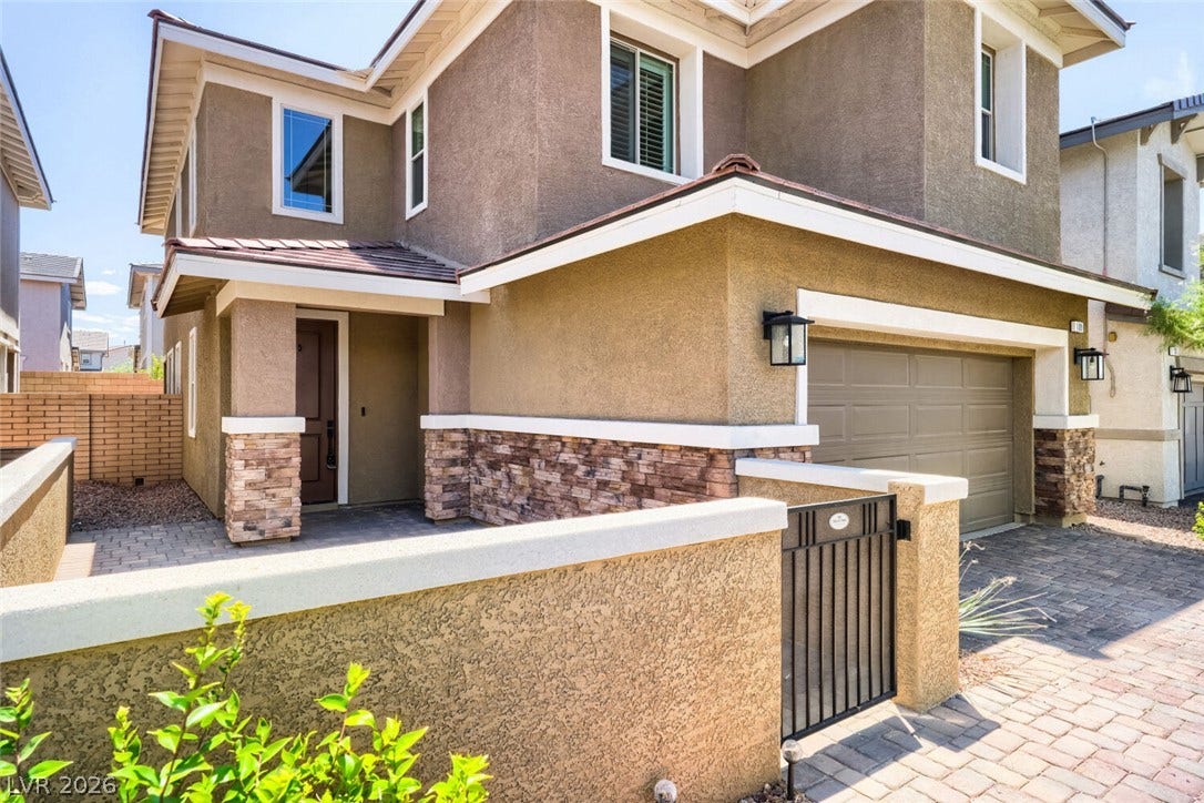 189 Lilt Avenue, Henderson, NV 89011 A welcoming entry with paver walkways leads to a home featuring both stucco and stone veneer finishes.
