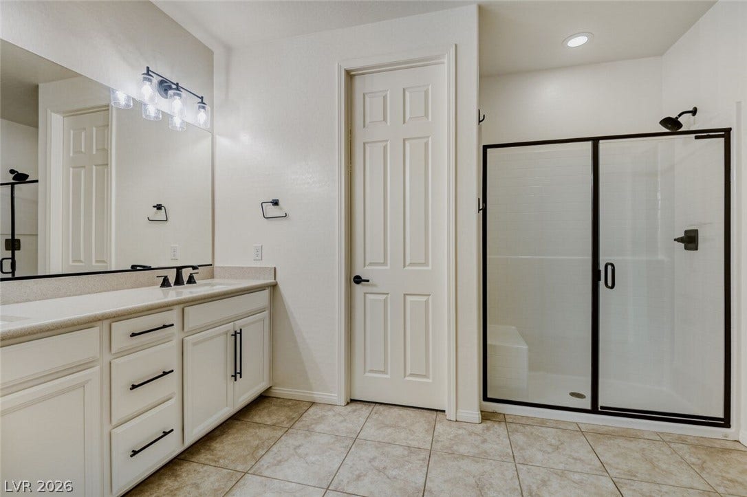 189 Lilt Avenue, Henderson, NV 89011 A well-appointed bathroom features a spacious vanity and a walk-in shower with sleek glass doors.