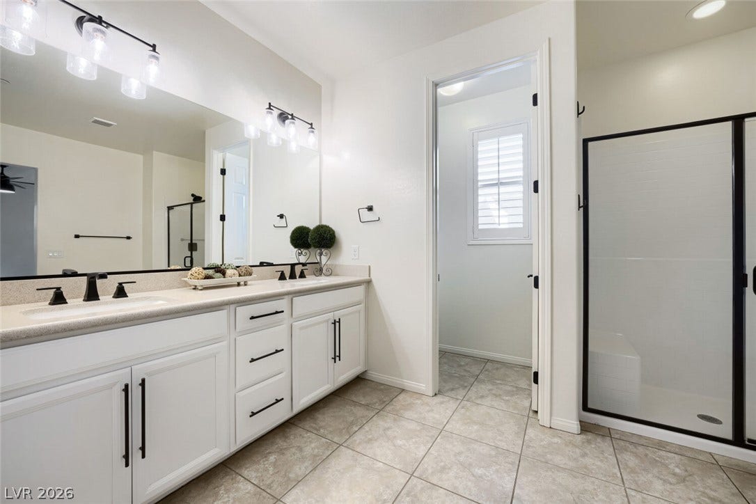 189 Lilt Avenue, Henderson, NV 89011 Dual vanities and a spacious glass-enclosed shower create a serene bathing experience.