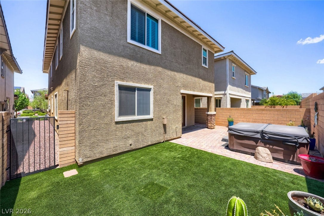189 Lilt Avenue, Henderson, NV 89011 A private backyard oasis features artificial turf, a paver patio, and a covered spa area.