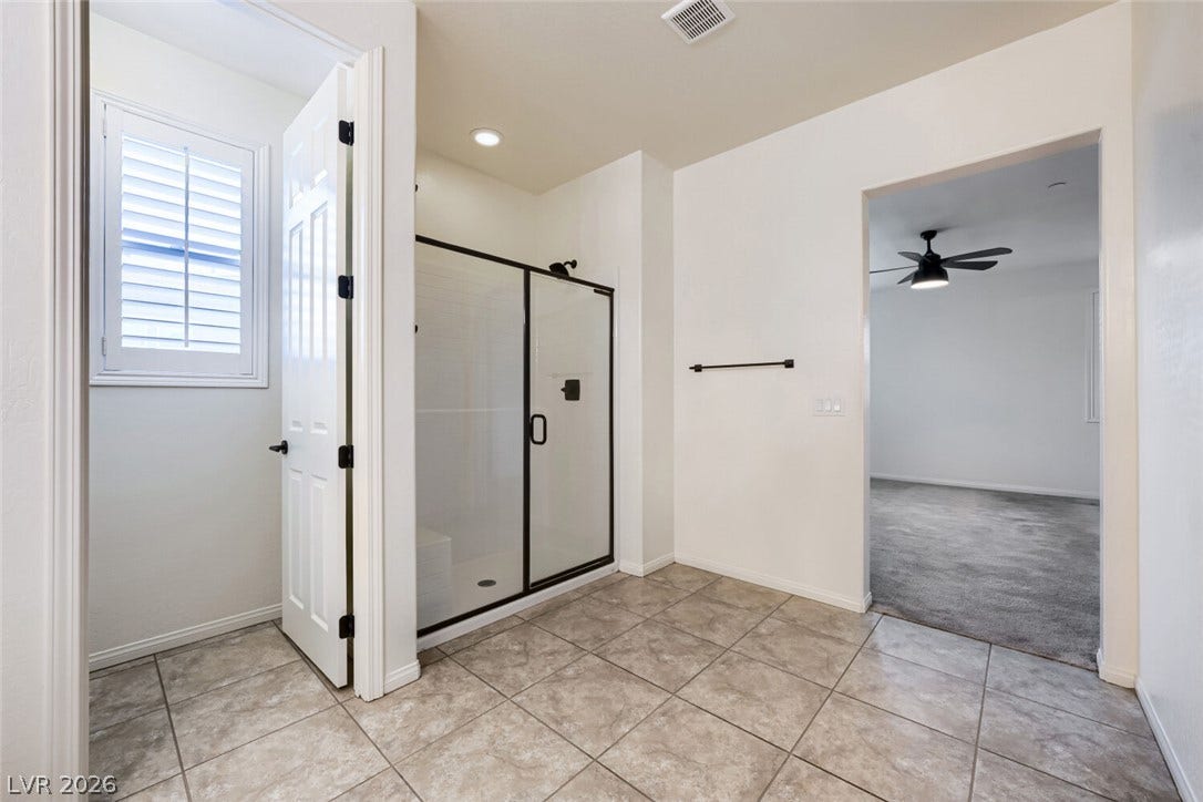 189 Lilt Avenue, Henderson, NV 89011 A well-lit primary bathroom with a spacious glass-enclosed shower.