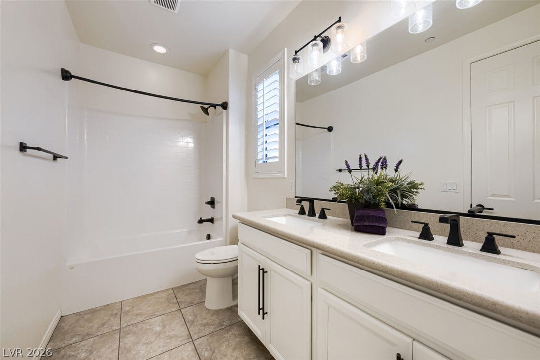 189 Lilt Avenue, Henderson, NV 89011 A well-appointed bath features a double vanity and sleek modern fixtures.