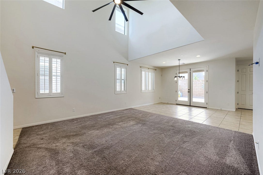 189 Lilt Avenue, Henderson, NV 89011 A grand living space with towering vaulted ceilings and a blend of carpet and tile flooring.
