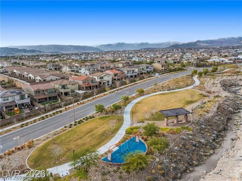 600 N Carriage Hill Drive, #1034, Las Vegas, NV 89138 An aerial perspective reveals a vibrant community nestled among the mountains, featuring a well-maintained park and winding pathways.
