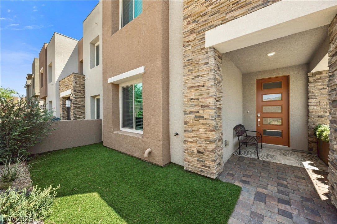 600 N Carriage Hill Drive, #1034, Las Vegas, NV 89138 Modern townhome boasts clean lines, stone accents, and a welcoming front entrance with low-maintenance landscaping.