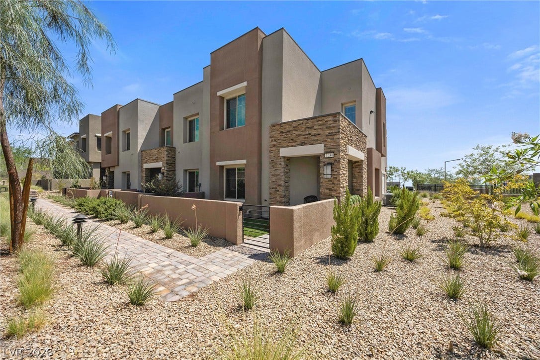 600 N Carriage Hill Drive, #1034, Las Vegas, NV 89138 Modern townhomes showcasing desert-friendly landscaping and an inviting stone faade entrance.