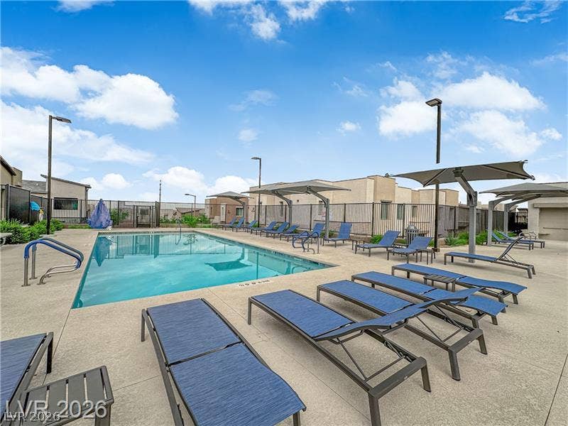 600 N Carriage Hill Drive, #1034, Las Vegas, NV 89138 A refreshing pool area with numerous chaise lounges invites relaxation under a bright sky.