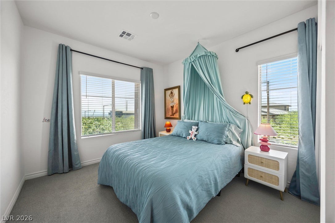 600 N Carriage Hill Drive, #1034, Las Vegas, NV 89138 A well-lit bedroom features plush carpeting and broad windows.
