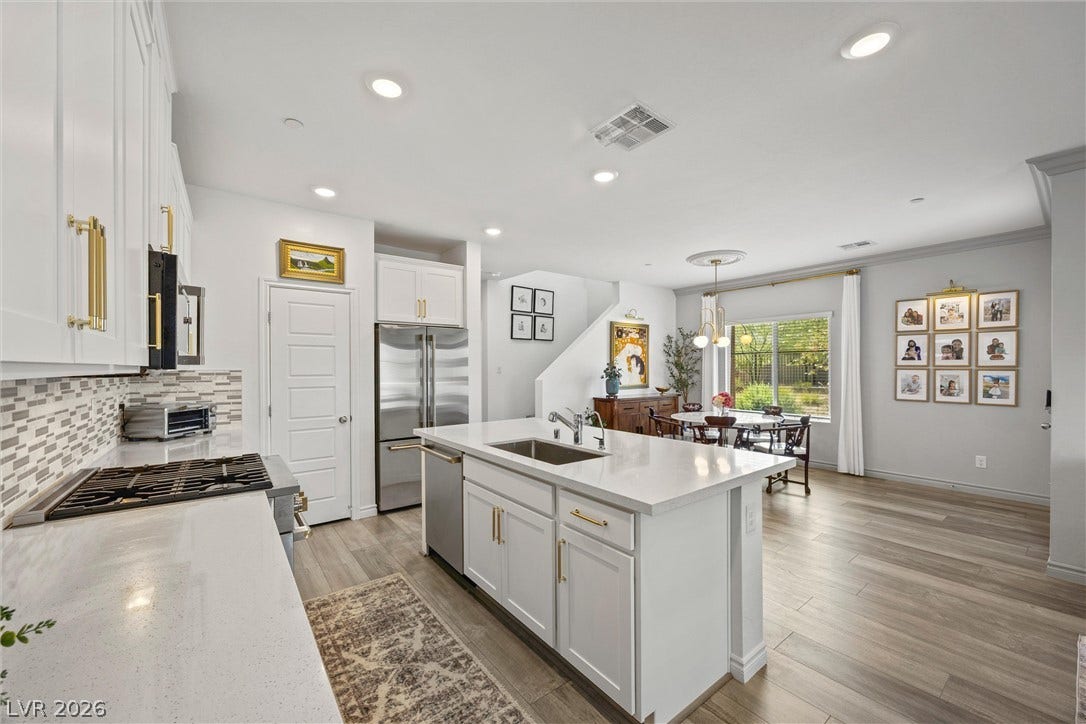 600 N Carriage Hill Drive, #1034, Las Vegas, NV 89138 A well-lit kitchen with sleek white cabinetry and a central island offers an inviting culinary space.
