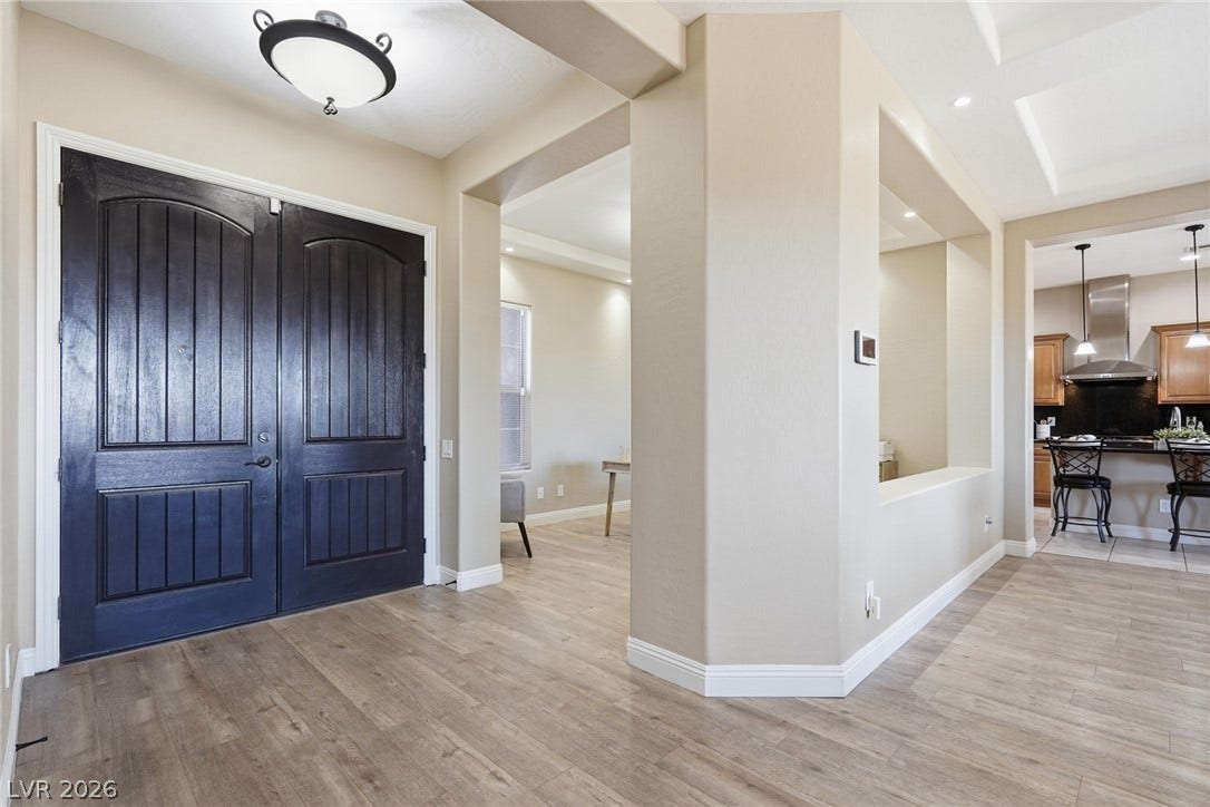 2397 Luberon Drive, Henderson, NV 89044 Enter through dark wood double doors into a welcoming foyer with natural wood flooring and elegant archways.