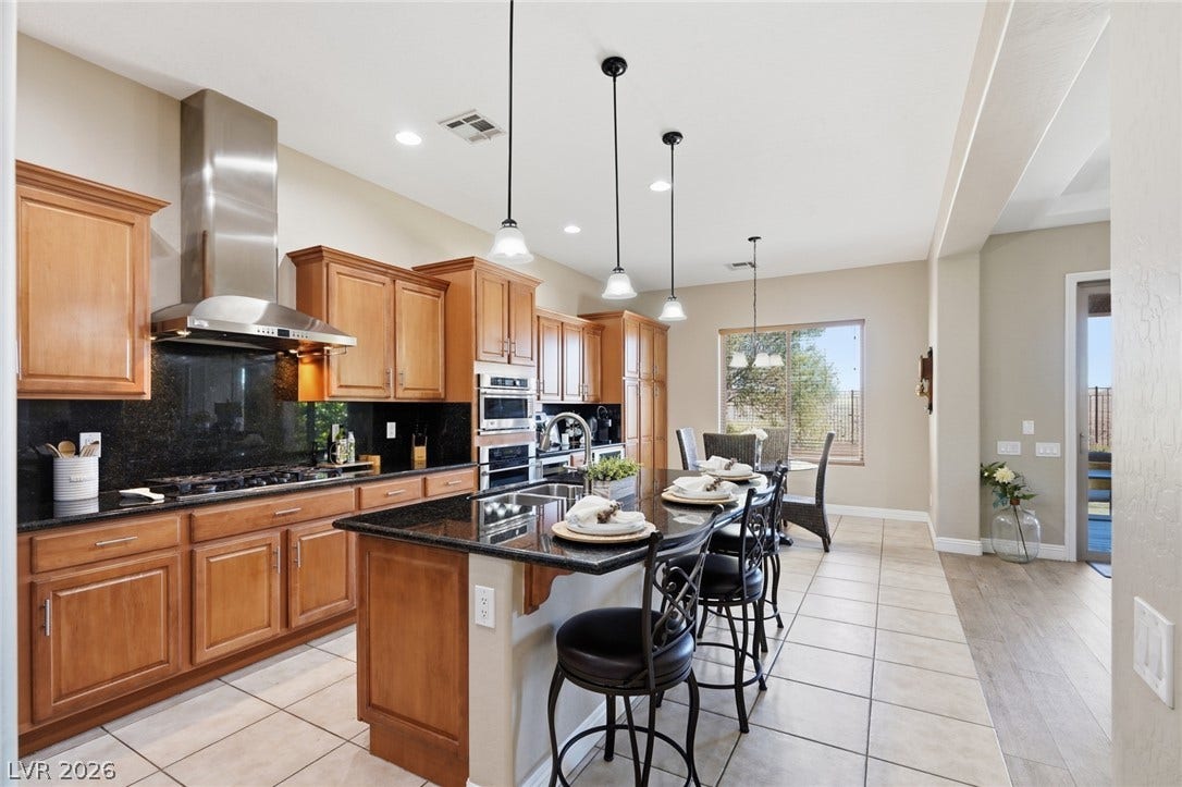 2397 Luberon Drive, Henderson, NV 89044 A gourmet kitchen offers rich wood cabinetry, granite countertops, and modern appliances.