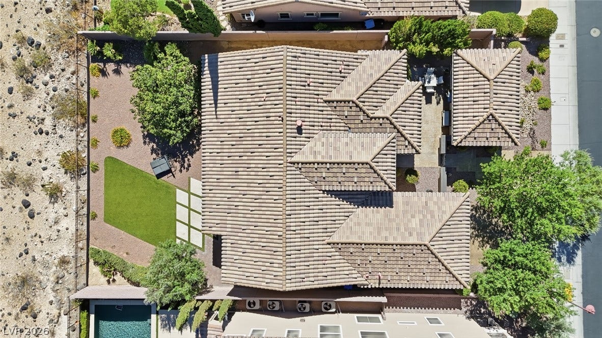 2397 Luberon Drive, Henderson, NV 89044 An aerial perspective showcases the tiled rooflines of this residence, complemented by an inviting swimming pool and lush landscaping.