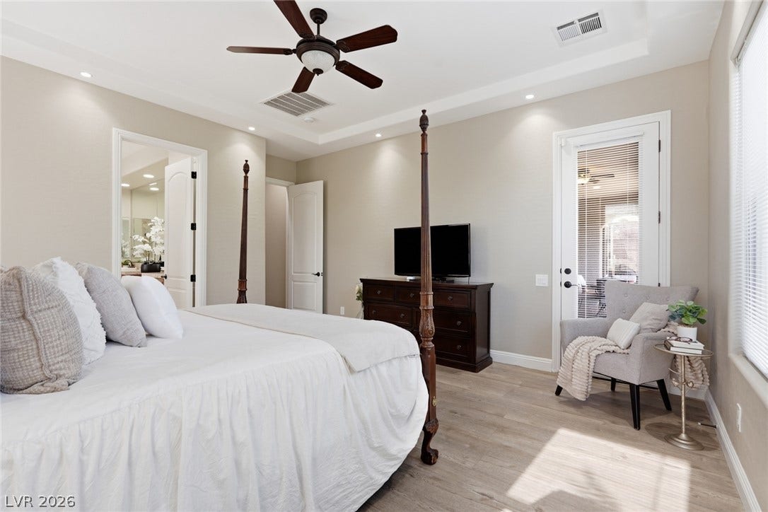 2397 Luberon Drive, Henderson, NV 89044 Relaxation abounds in this primary bedroom featuring ample natural light and a private patio entrance.