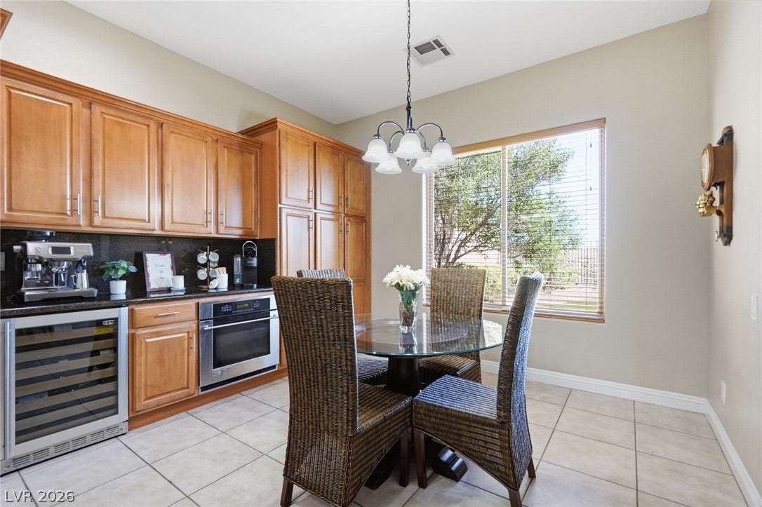 2397 Luberon Drive, Henderson, NV 89044 Functional kitchen with warm wood cabinetry, modern appliances, and a sunlit dining area.