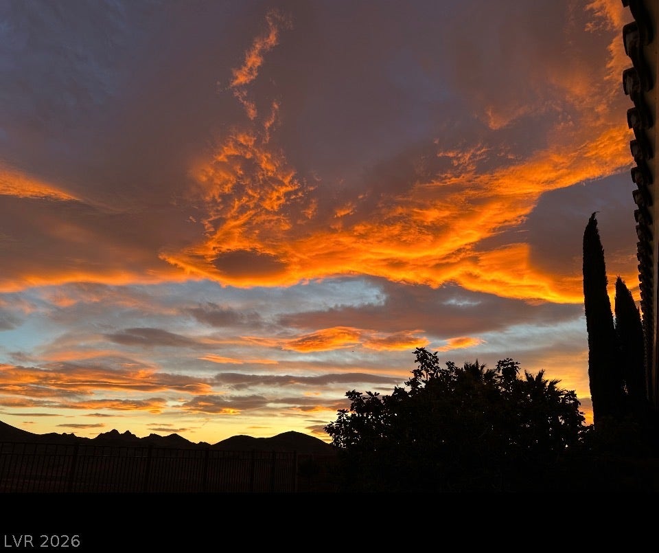 2397 Luberon Drive, Henderson, NV 89044 Golden hour illuminates dramatic skies above distant peaks, painting a captivating desert panorama.