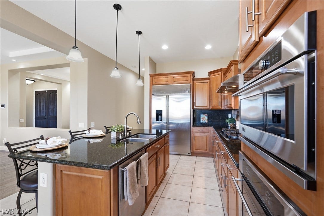 2397 Luberon Drive, Henderson, NV 89044 Culinary delights await in this gourmet kitchen featuring rich wood cabinetry and ample counter space.