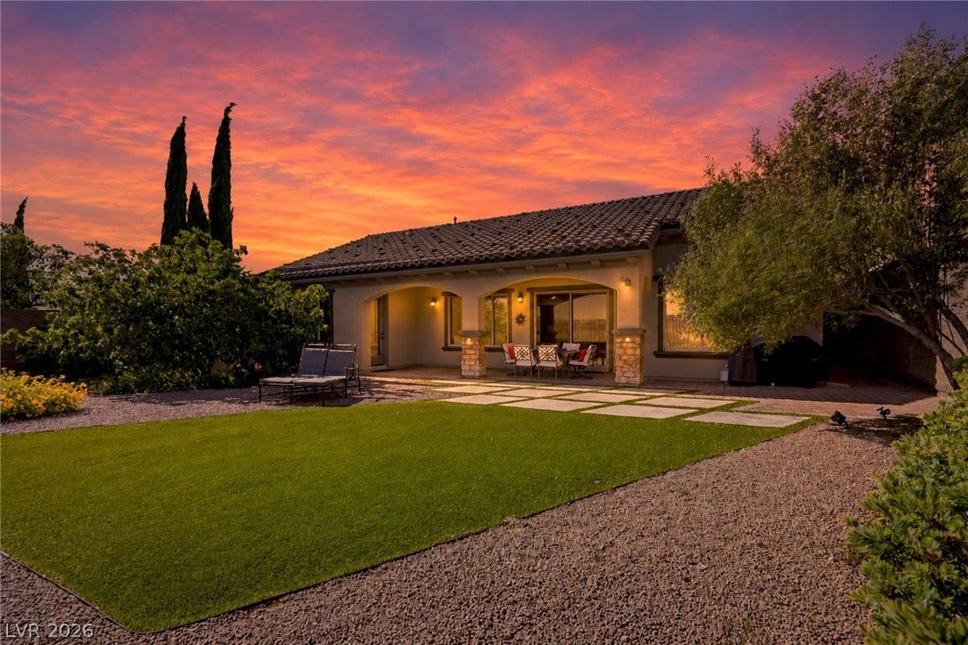 2397 Luberon Drive, Henderson, NV 89044 An inviting backyard offers an ideal space for entertaining under a vibrant sunset.