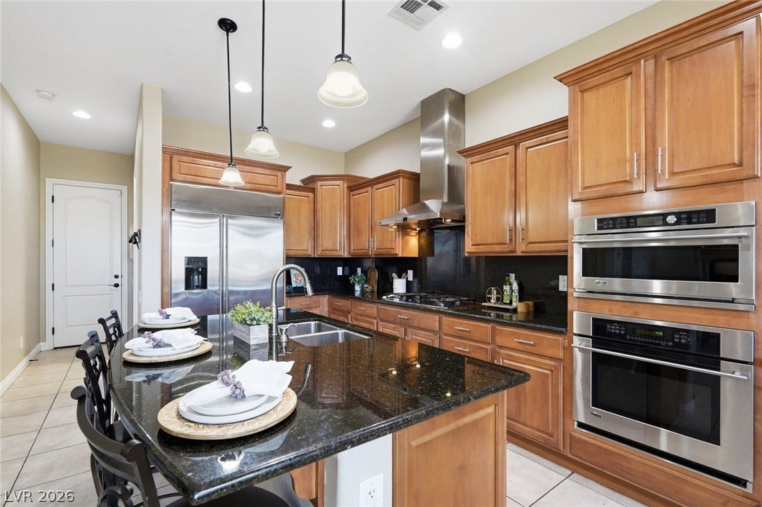 2397 Luberon Drive, Henderson, NV 89044 Culinary delights await in this chef's kitchen, showcasing a spacious island with sink and modern stainless steel appliances.