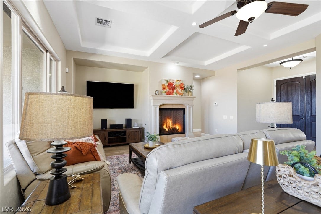 2397 Luberon Drive, Henderson, NV 89044 A comforting glow emanates from the fireplace, complemented by the elegant tray ceilings.